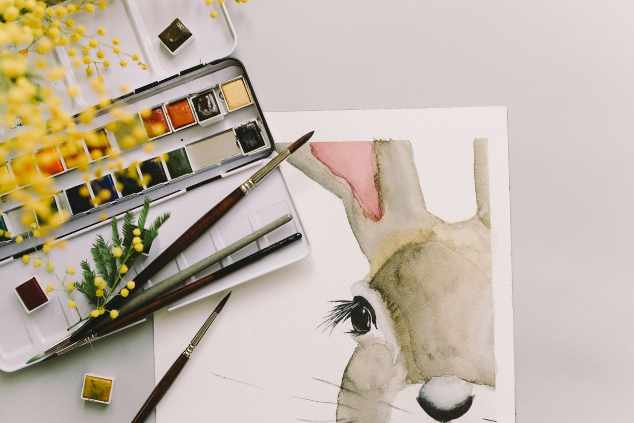 Artistic Easter bunny watercolor with brush and mimosa flowers on a spring day.