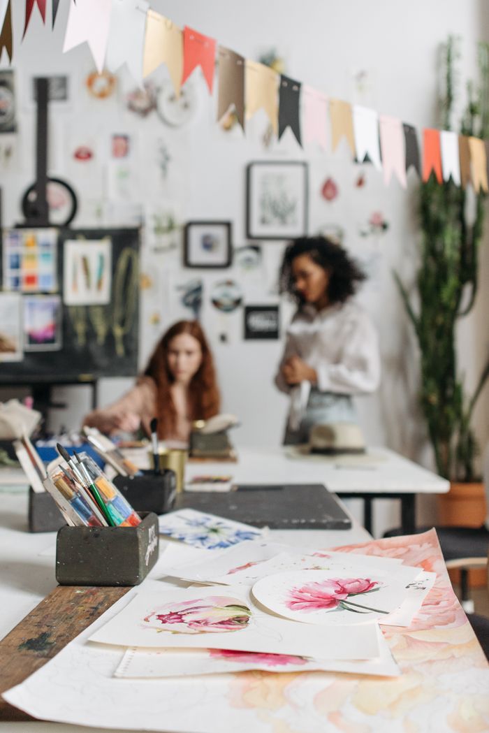 services-01 Vibrant art studio featuring watercolor paintings and creative individuals working on new artworks.